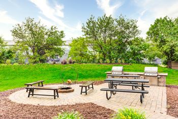 a picnic area with two picnic tables and a grill